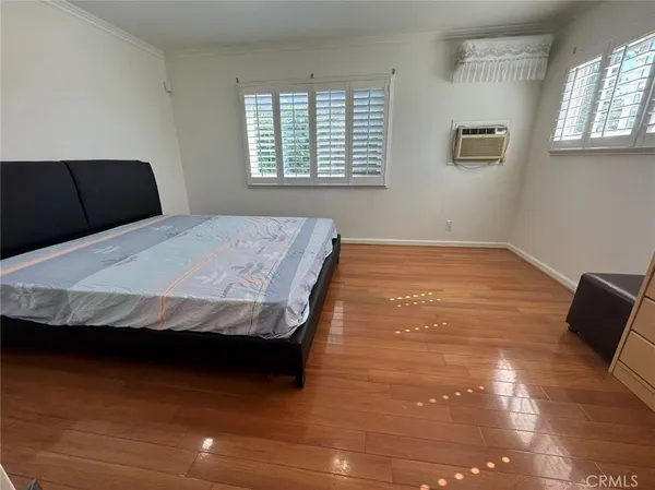 a bedroom with a bed and wooden floor
