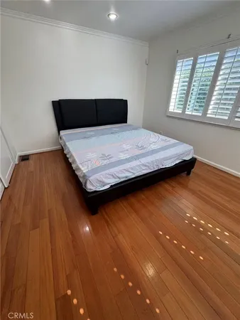 a bedroom with a bed and wooden floor