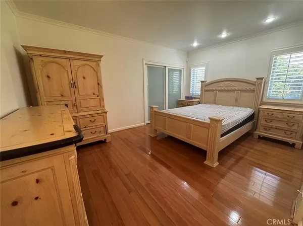 a bedroom with a bed and large windows