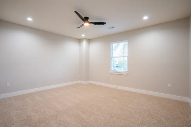 an empty room with a ceiling fan and window
