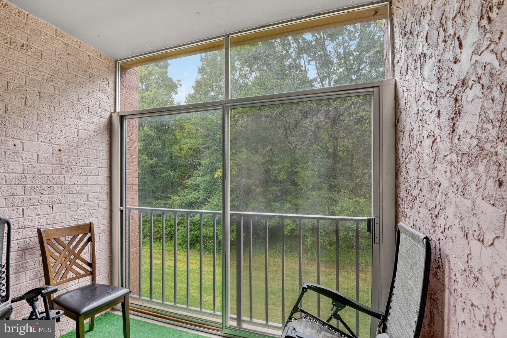 8007 Mandan Road, Unit 203 Greenbelt, MD 20770 - Photo 10 of 25 a view of a balcony with chairs and floor to ceiling window