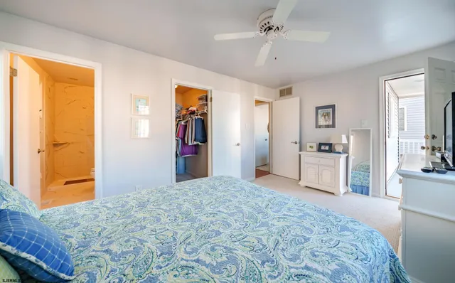 a bedroom with a large bed a chandelier and closet