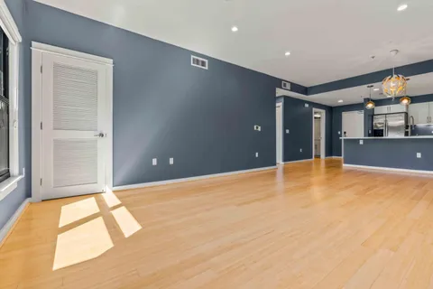 a view of an empty room with kitchen natural and a window