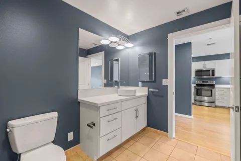 a spacious bathroom with a toilet sink and mirror
