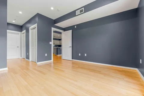 a view of an empty room with wooden floor