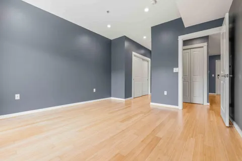 a view of an empty room with wooden floor