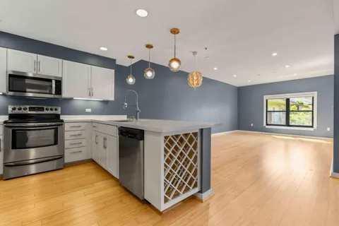 a kitchen with stainless steel appliances granite countertop a sink a stove and a refrigerator