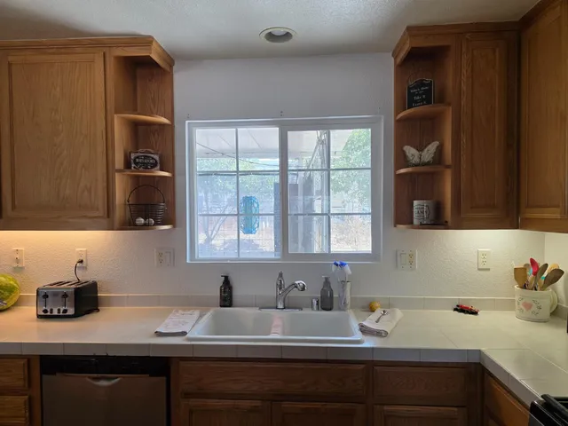 a kitchen with a sink dishwasher a stove top oven a refrigerator with island and chairs