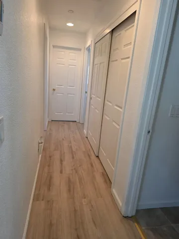 a view of a hallway with wooden floor and front door
