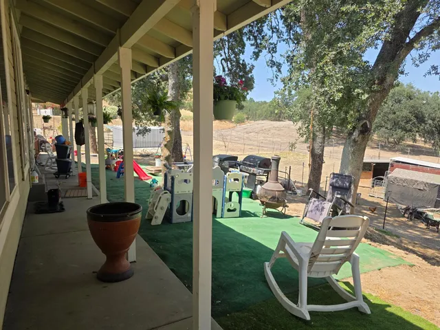 a view of a patio with chairs and a grill