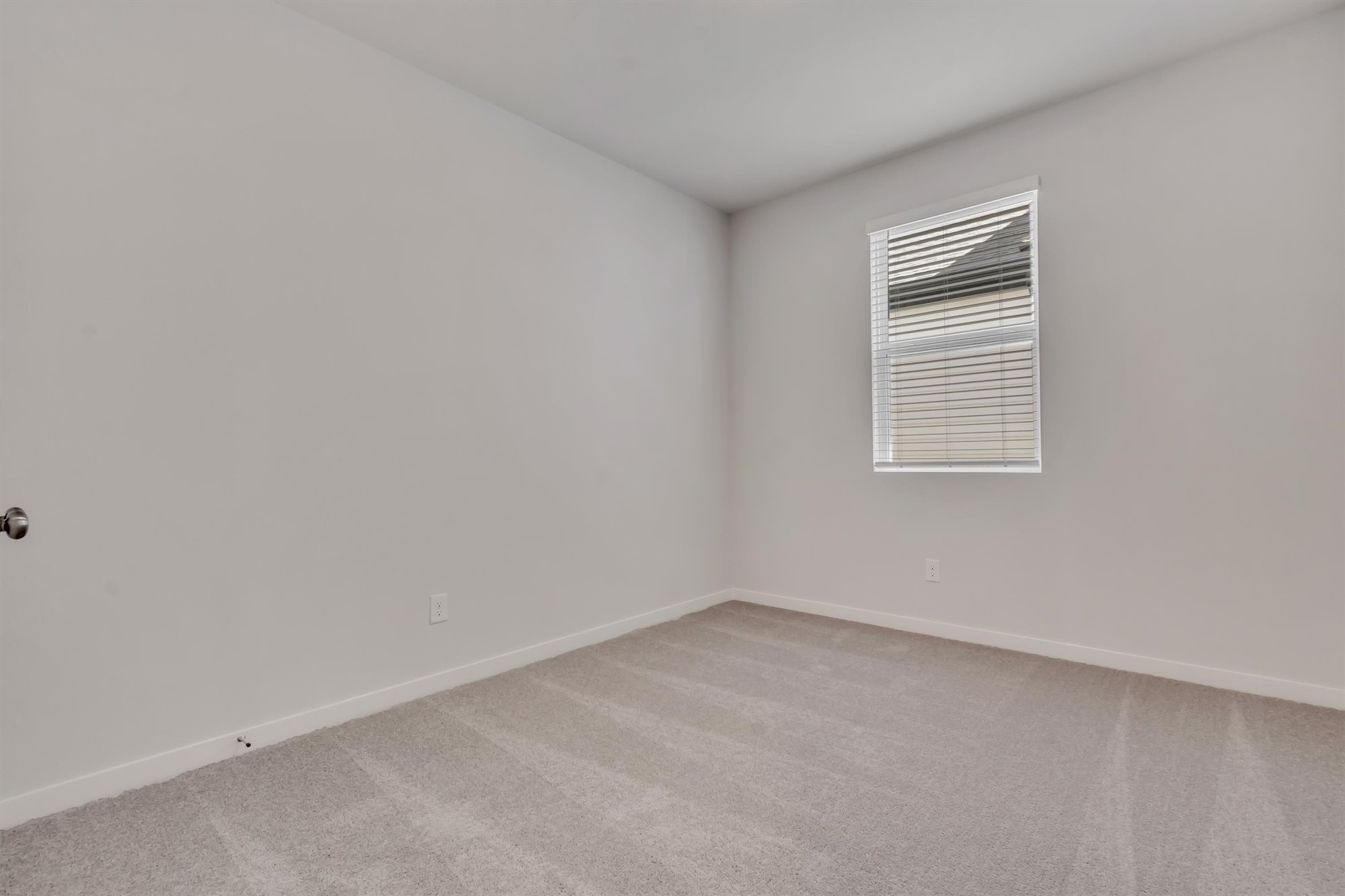 228 Bendecido Loop Elgin, TX 78621 - Photo 14 of 16 A spacious, naturally illuminated room features plush carpet and a well-placed window with blinds.