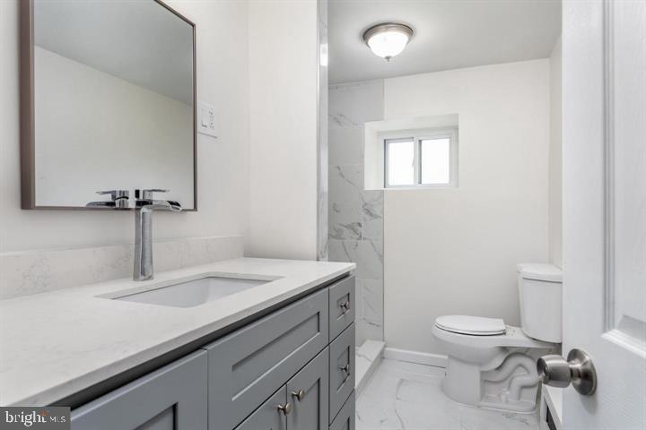 120 Grape Street Philadelphia, PA 19127 - Photo 9 of 24 a bathroom with a granite countertop sink a toilet and a mirror