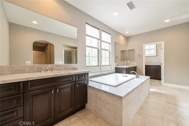 a spacious bathroom with a granite countertop tub sink and mirror