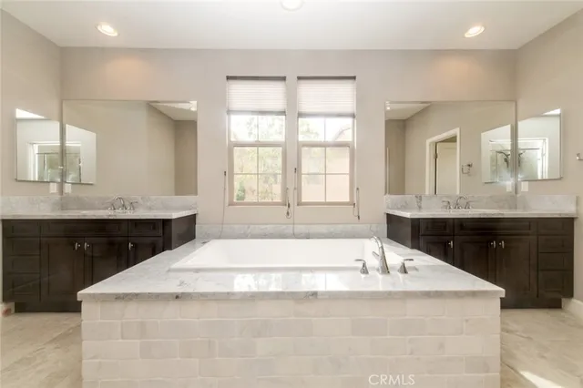 a bathroom with a granite countertop bathtub sink vanity and mirror