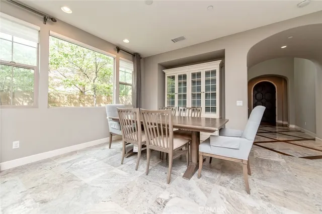 a dining room with furniture and large windows