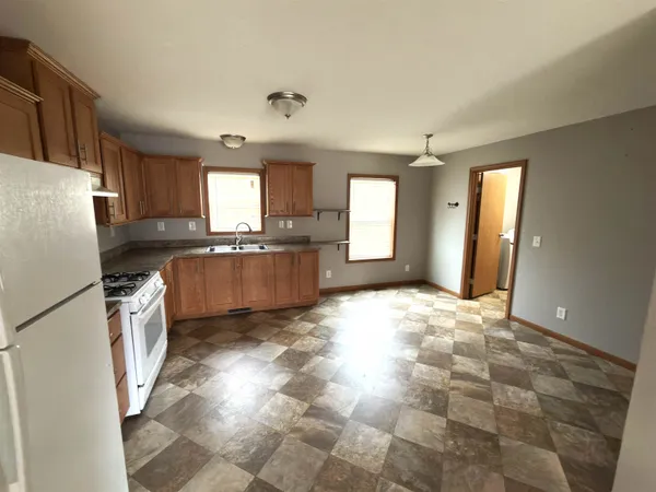 a kitchen with granite countertop a refrigerator and a stove top oven