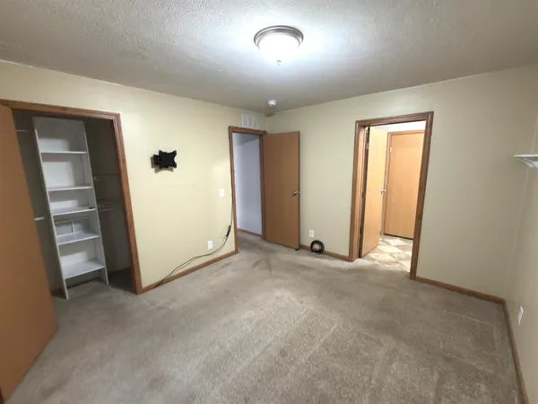 an empty room with closet and windows