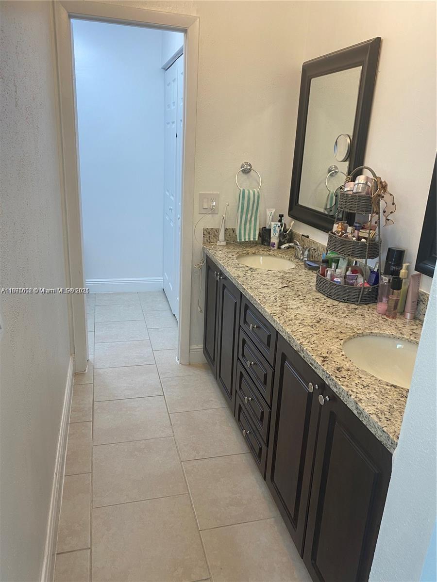 13208 Southwest 10th Lane Miami, FL 33184 - Photo 9 of 10 a bathroom with a granite countertop sink a mirror and vanity