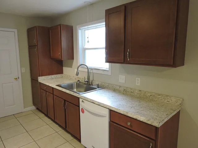 a kitchen with a sink cabinets and a window