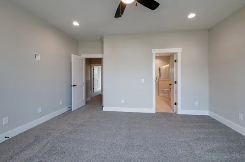 an empty room with ceiling fan and entryway