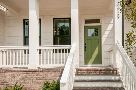 a view of a house with a small yard and wooden floor and fence