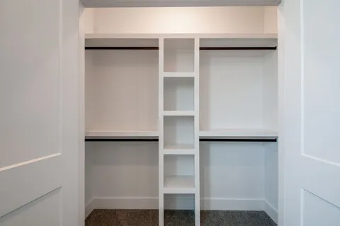 a view of walk in closet with empty racks