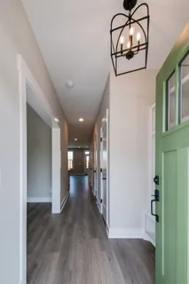 a view of hallway with wooden floor and chandelier