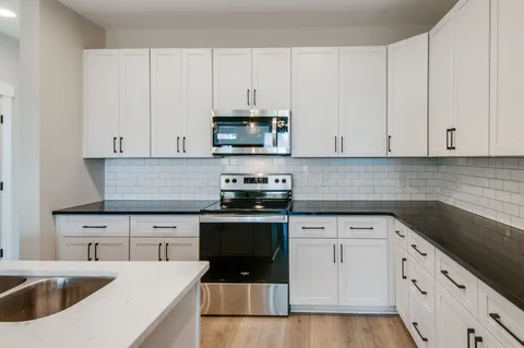 a kitchen with white cabinets and white appliances