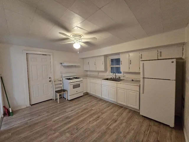 a kitchen with white cabinets and white appliances
