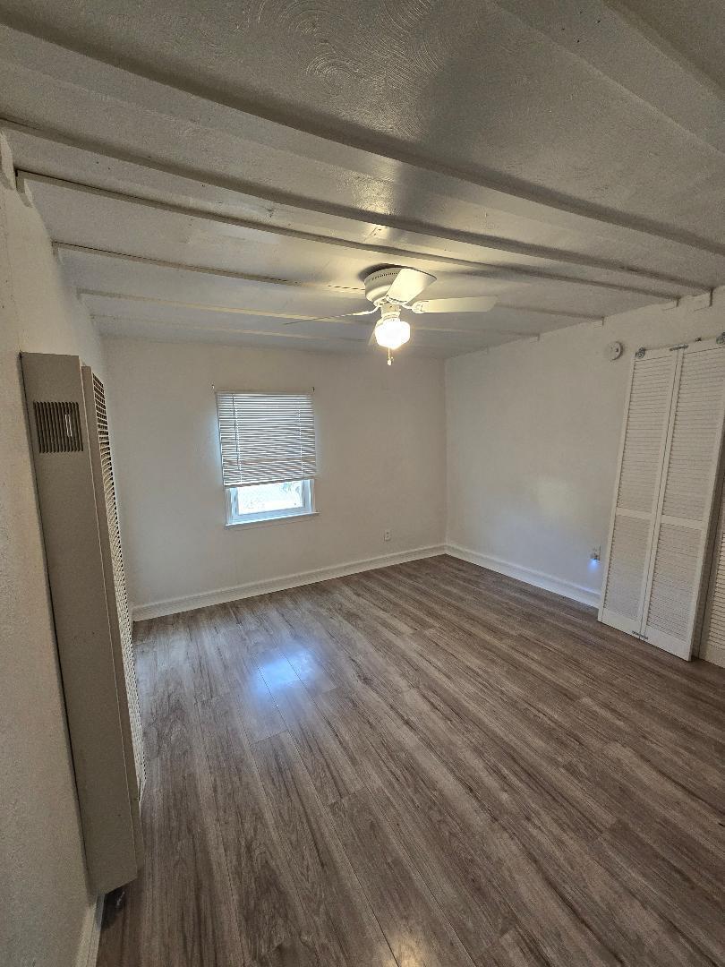 702 North Ave O Lamesa, TX 79331 - Photo 5 of 12 a view of an empty room with wooden floor and a window