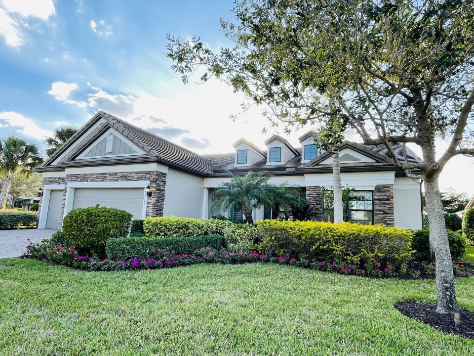 16163 Cartwright Lane Naples, FL 34110 - Photo 2 of 35 a front view of a house with a garden