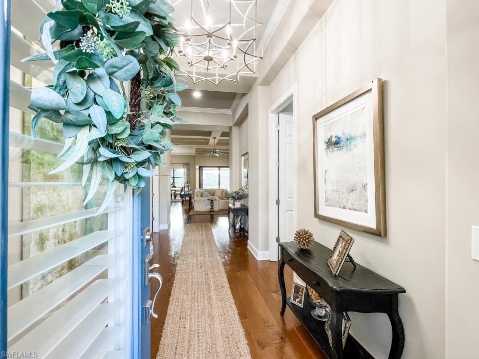 16163 Cartwright Lane Naples, FL 34110 - Photo 4 of 35 a dining room with furniture a chandelier and wooden floor