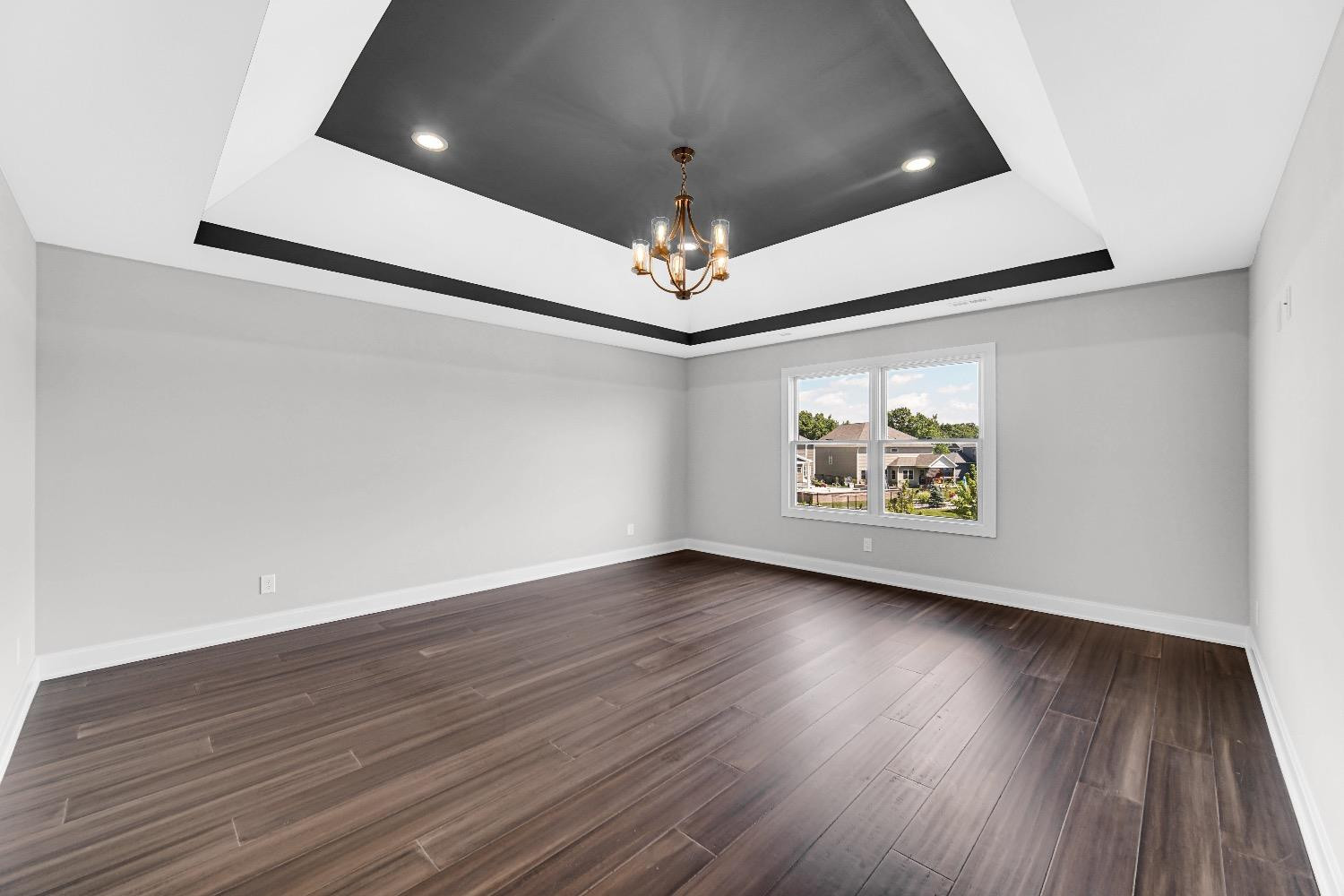 11039 Macedon Street Winfield, IN 46307 - Photo 26 of 36 an empty room with wooden floor chandelier fan and windows
