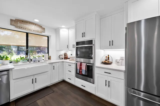 a kitchen with stainless steel appliances white cabinets and a refrigerator