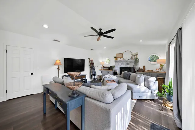 a living room with furniture a flat screen tv and a fireplace