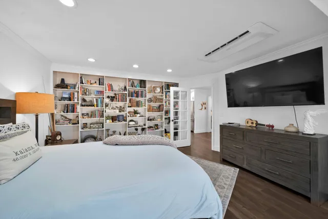 a large bedroom with a bed and flat screen tv