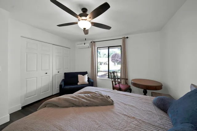 a bedroom with a bed and a large window