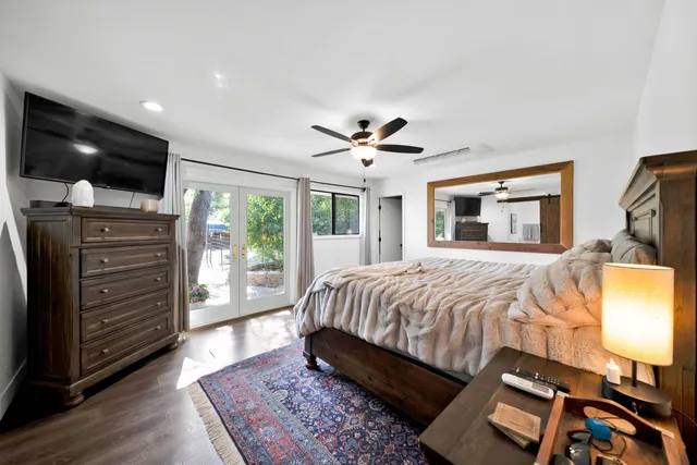 a spacious bedroom with a bed and a flat screen tv