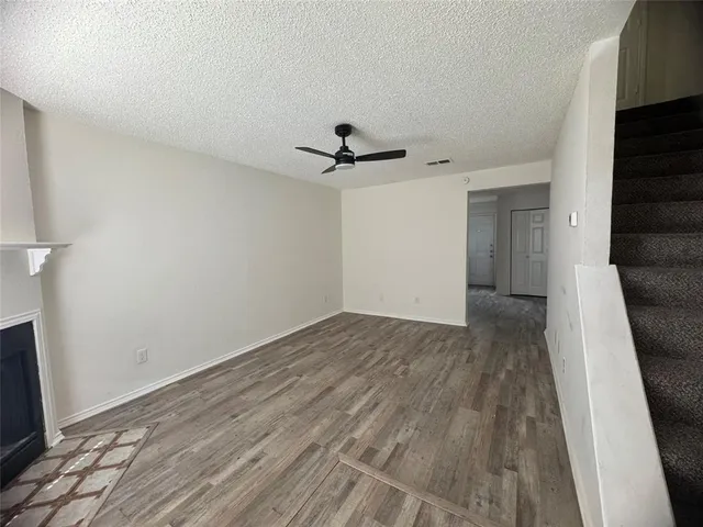 a view of a livingroom with wooden floor and a ceiling fan