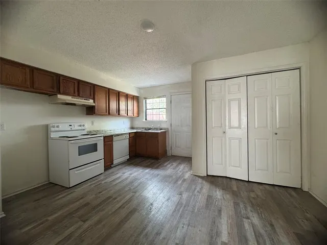 a kitchen with stainless steel appliances a white stove top oven and cabinets