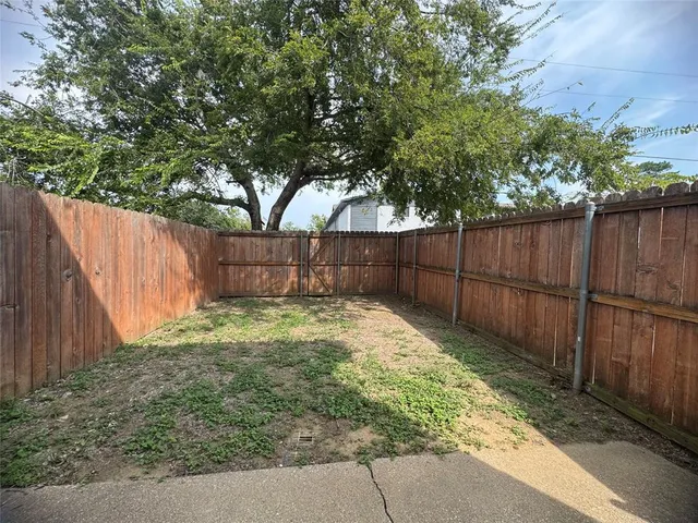 a view of backyard with wooden fence