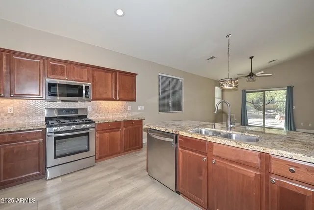 a kitchen with stainless steel appliances granite countertop a sink and stove top oven