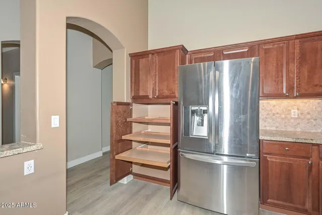 a metallic refrigerator freezer sitting in a kitchen