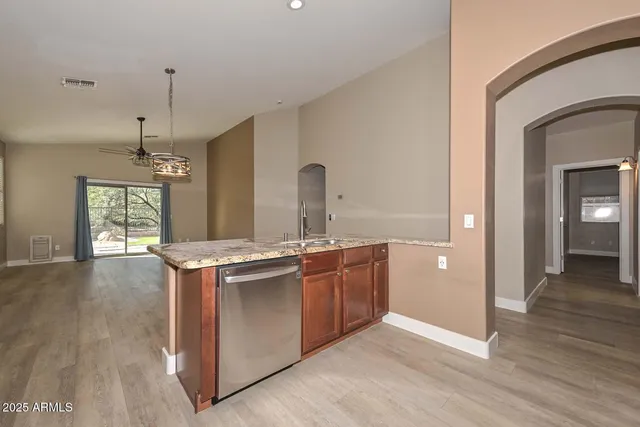 a kitchen with stainless steel appliances granite countertop a stove and a wooden floors