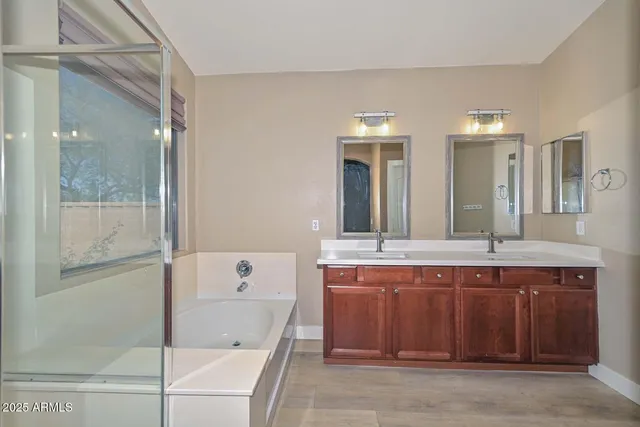 a bathroom with a tub sink and mirror