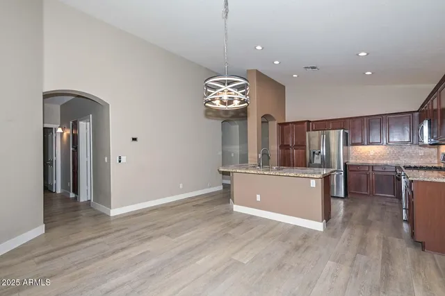 a large kitchen with a wooden floor and stainless steel appliances
