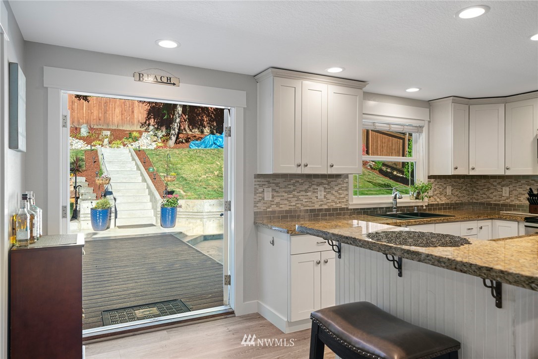 23019 19th Drive Southeast Bothell, WA 98021 - Photo 12 of 28 a view of a kitchen with a sink and dishwasher with wooden floor