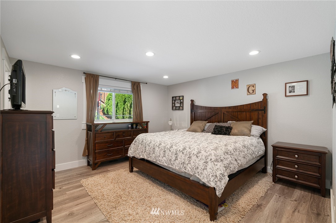 23019 19th Drive Southeast Bothell, WA 98021 - Photo 17 of 28 a bedroom with a bed and a dresser with wooden floor