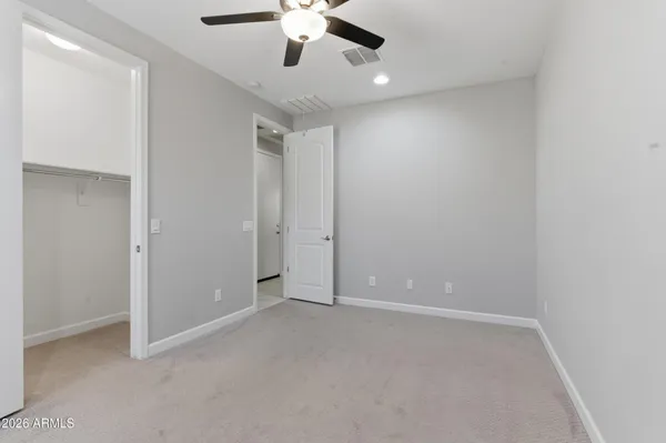an empty room with chandelier fan