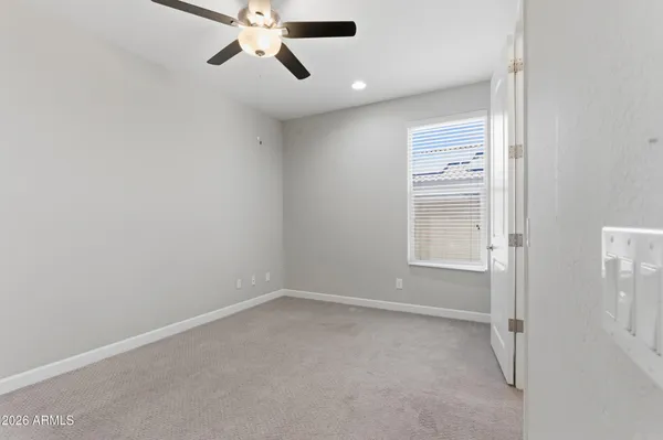 an empty room with a ceiling fan and window
